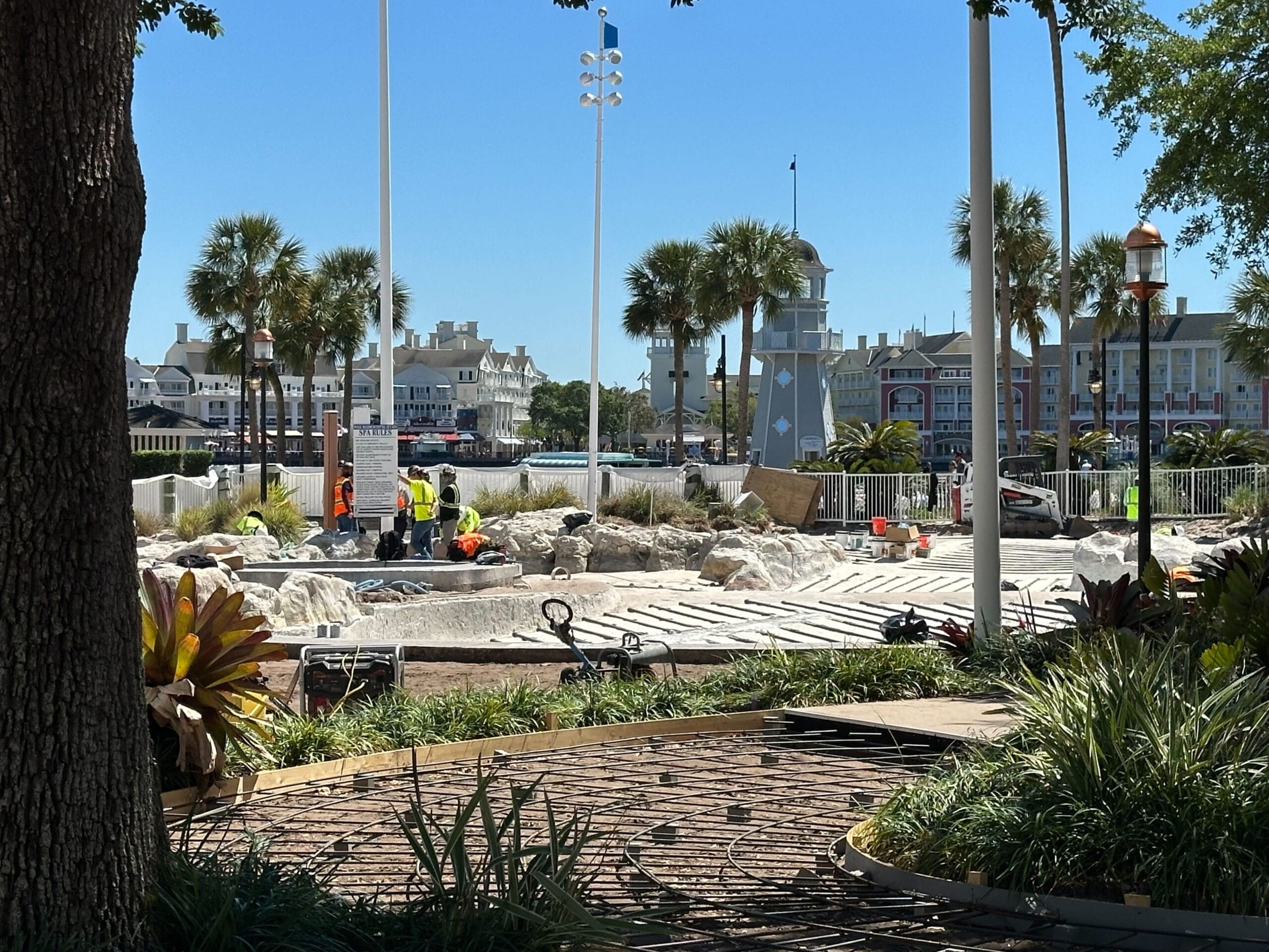 Amidst the construction site, workers diligently labor surrounded by palm trees and buildings, reminiscent of the bustling atmosphere near Disney's Yacht Club. Equipment and materials are scattered around under a clear blue sky, evoking a scene similar to the vibrant Stormalong Bay Pool. Amidst the construction site, workers diligently labor surrounded by palm trees and buildings, reminiscent of the bustling atmosphere near Disney's Yacht Club. Equipment and materials are scattered around under a clear blue sky, evoking a scene similar to the vibrant Stormalong Bay Pool.